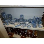 A shelf of blue jasperware china including vases, plates, trinket boxes and covers, lighters,