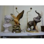 A brass table lamp with a large elephant figure and another large eagle brass table lamp and a white