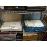 A vintage suitcase and a carton of good quality table linen including embroidered and damask table