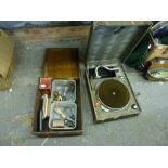 A vintage wind-up portable gramophone and a box containing vintage light bulbs and electrical