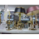 Three brass table lamps two with shades, one in a classical Greek column style the further two