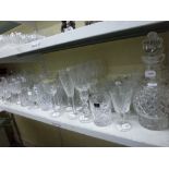 A shelf of glassware including eight Royal Doulton whisky tumblers, two Royal Doulton decanters