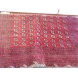 A large Afghan Daulautabad carpet woven with rows of guls on a crimson field within concentric