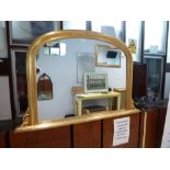 A reproduction Victorian overmantel mirror within a moulded gilt wood frame, with arched top and