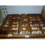 An extensive collection of thimbles, including some in silver, displayed in two compartmented trays,