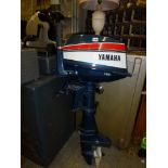 A Yamaha 8B 1-100 Outboard Motor and a Yamaha Outdoor Motor P45. [in front of garage doors] TO BID