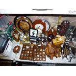 A shelf of wooden and metal wares including wooden trays, clocks, bowls, table lamp, trinket box