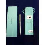 A silver ballpoint pen stamped 925 by Tiffany & Co, with pouch and box. TO BID ON THIS LOT AND FOR
