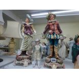 A pair of late 19th century Continental pottery figures of a cavalier and lady, each holding a