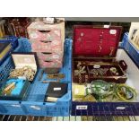A plastic tray and box lid containing costume jewellery, an old jewel box with a display of hat-