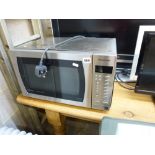 A Panasonic Microwave in a stainless steel cabinet. TO BID ON THIS LOT AND FOR VIEWING