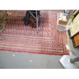 A large Eastern rug in Turkoman style woven with four rows of guls on a wine field [in front of