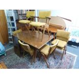 A 1950s extending rectangular dining table on stylish raked tapering legs and eight matching