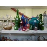 A small collection of coloured glassware including a ruby glass perfume bottle, green glass bottles,