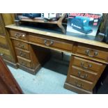 An early 20th century oak pedestal desk of nine drawers with original fabric top. TO BID ON THIS LOT