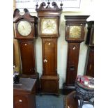 An early 19th century oak longcase clock, the shaped door with cross-banded decoration flanked by