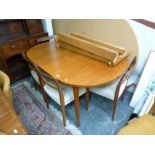 A 1960s oval extending dining table in teak and five matching ladder-back chairs. TO BID ON THIS LOT
