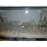 A shelf of glassware including brandy balloons, decanter and stopper, etched glass fruit bowls,