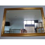A rectangular wall mirror, the bevelled glass within a stepped gilt wood frame (66 x 99 cm) TO BID