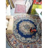 A machine-made circular rug woven with flowers on a navy ground, and a small wine-ground machine-