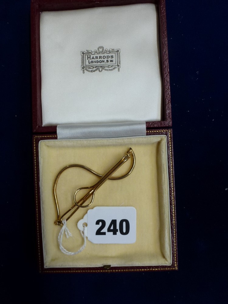 A 9 ct gold tie bar with safety chain, 6.9 gm, in Harrods box TO BID ON THIS LOT AND FOR VIEWING