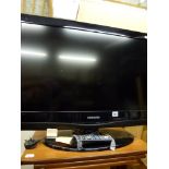 A Samsung flat screen television with remote control [end of second aisle] WE DO NOT TAKE CREDIT