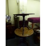 An early 19th century tilt-topped breakfast table in yew on a tripod based and another similar in