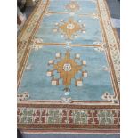 An Eastern rug, the blue ground divided into three windows each with a geometric design in brown