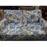 A bed settee within a two-seater sofa covered in blue floral fabric. WE DO NOT TAKE CREDIT CARDS