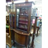 A charming Edwardian display cabinet, the upper section enclosed by a single door within a painted