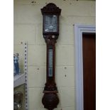 A fine carved oak stick barometer, signed W. Aronsberg & Co, Manchester [wall next to office] WE