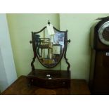 A George III mahogany dressing mirror the shield shaped glass above a serpentine base with three