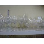 Two shelves of glassware comprising champagne flutes, wine glasses, brandy balloons, sherry glasses,