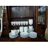 A white glazed part dinner service including plates, bowls and mugs, plus six stainless steel candle