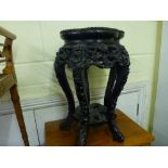 A small Eastern stand in carved ebony with a marble inset top. WE DO NOT TAKE CREDIT CARDS OR