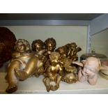 A number of decorative gold painted cherub ornaments, a small planter with a cherub surmount, a blue
