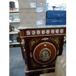 A glamorous French pier cabinet the marble top above a frieze of porcelain floral discs and a