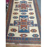 A woollen rug, possibly Turkish, with geometric decoration on a cream ground with blue and brown