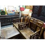 A pair of antique Chinese chairs each with a carved panel back and shaped arms and a similar