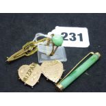 A 9 ct gold ring claw-set with a jadeite cabochon; a Chinese gold and jadeite bar brooch; a