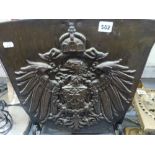 A bronze shield from the front of a steam locomotive which has been mounted and modelled into a