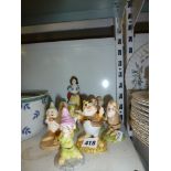 A set of Royal Doulton Snow White figurines comprising Snow White and the seven dwarves. [s18] WE DO