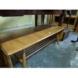 An Ercol light oak rectangular coffee table with flap ends above magazine rack supports between