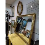 A large rectangular gilt framed bevel-edged mirror and an ornate oval framed mirror WE DO NOT TAKE