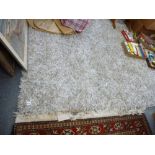 A modern rug in beige from Designer's Guild, shaggy in different textures. [top of the stairs] WE DO