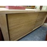 A substantial modern sideboard in bleached oak comprising two drawers flanked by a cupboard with