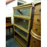 An oak sectionalized bookcase in the style of Globe Wernicke with four sections above a drawer. WE