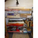 Four shelves of assorted RC modellers' paraphernalia including parts, accessories, tools, decals,