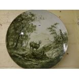 A large Continental pottery charger, circa 1900, painted in dark green with stags in combat, 60