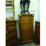 A late Victorian Wellington chest of seven drawers each with a turned wooden handle. WE DO NOT